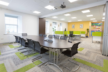 Conference room in Kilrush Digital Hub with hot-desks in background